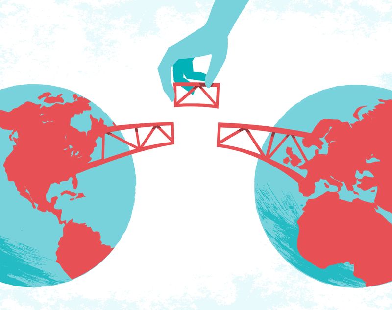 A hand grips a red and blue flag over a globe, representing the concept of cross-border mergers and global partnerships.