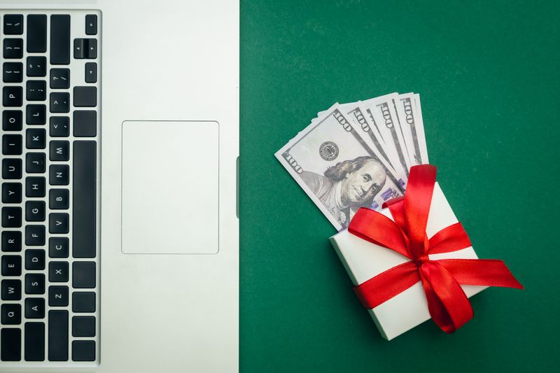 A laptop and stacks of money on a green background, symbolizing financial management and gift tax planning.
